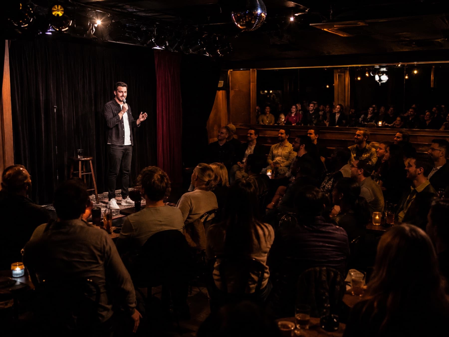 A stand-up comedy room under warm lights
